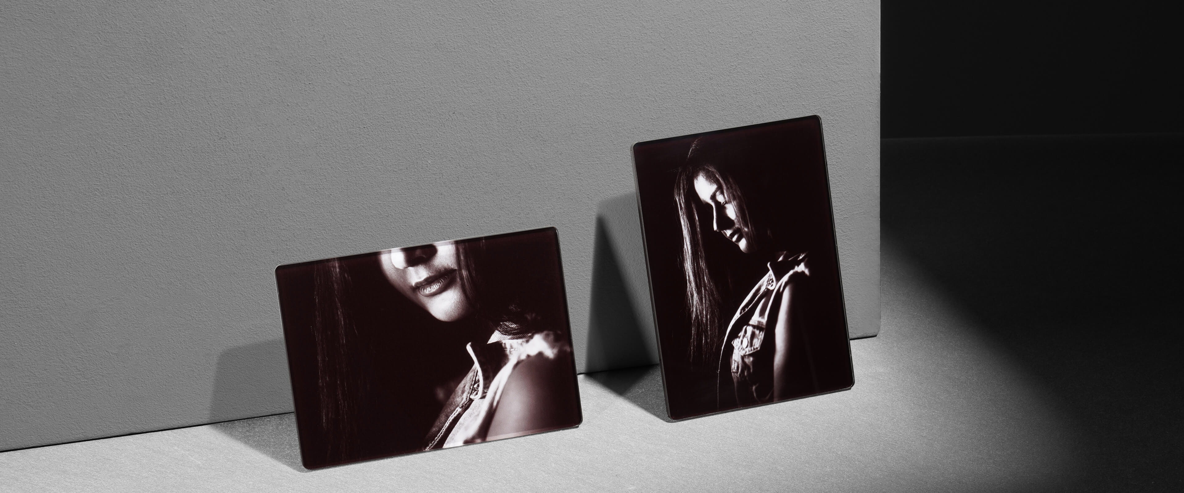 two acrylic photo plaques in different orientations standing on a white table showing a woman
