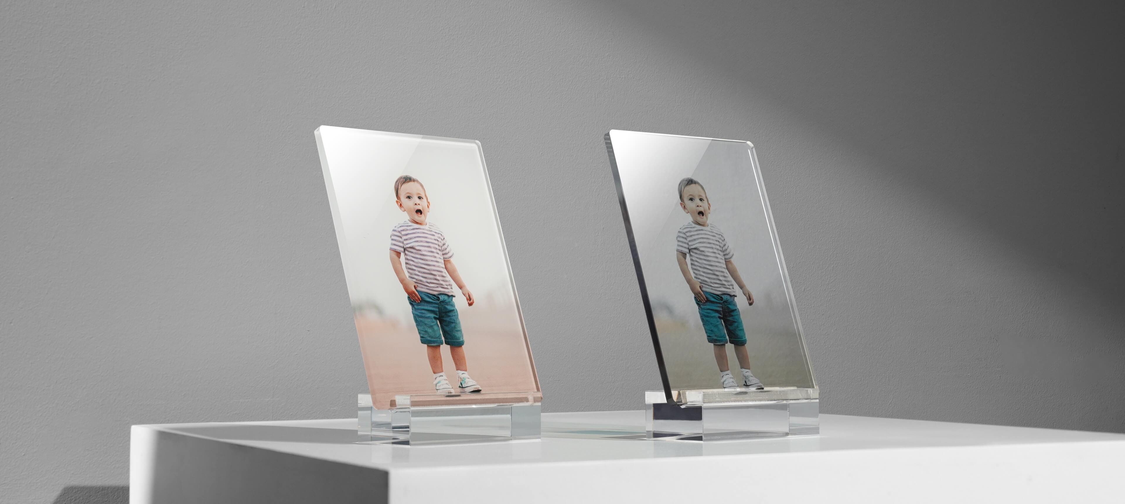 two acrylic photo stands on white table in different image options showing a kid surprised