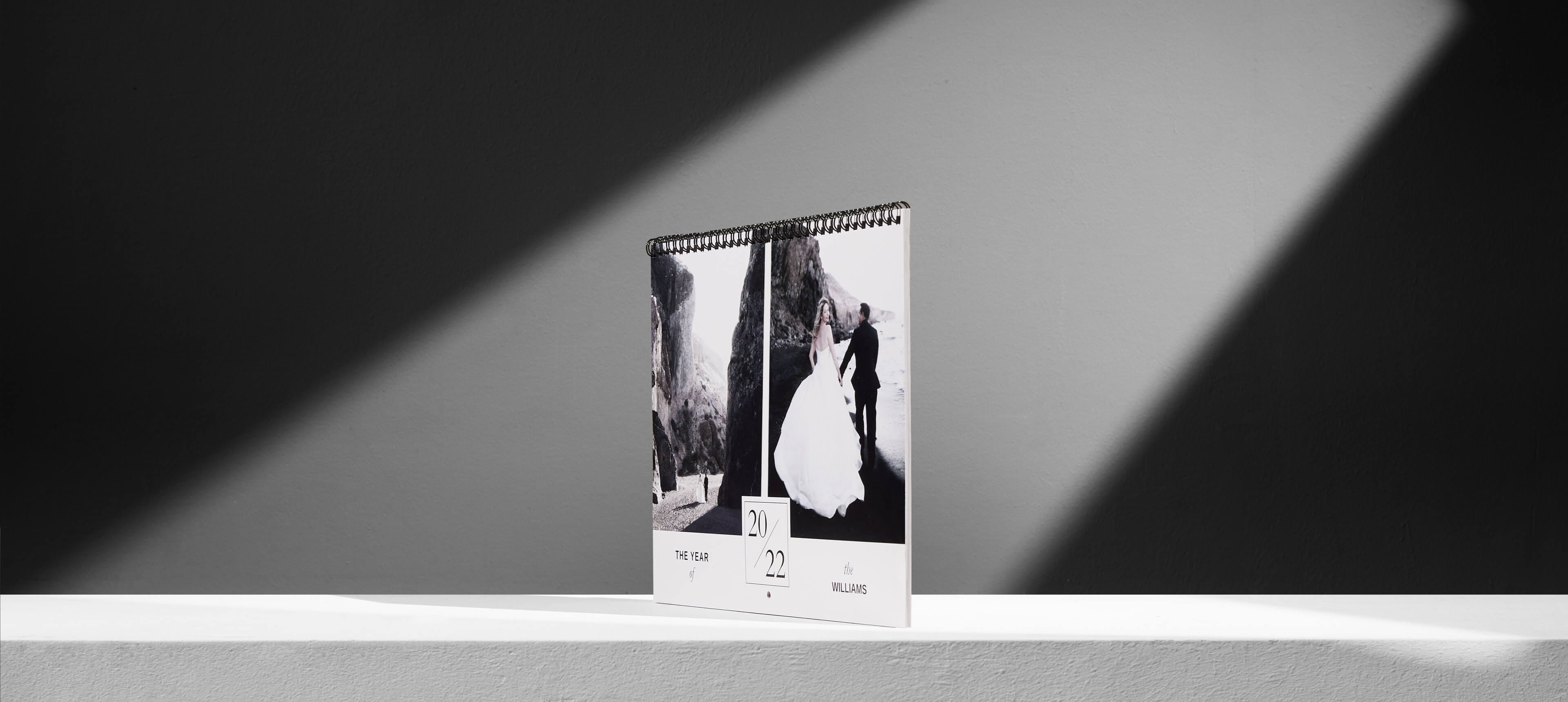 two classic wall calendars on a white table showing a bride and groom