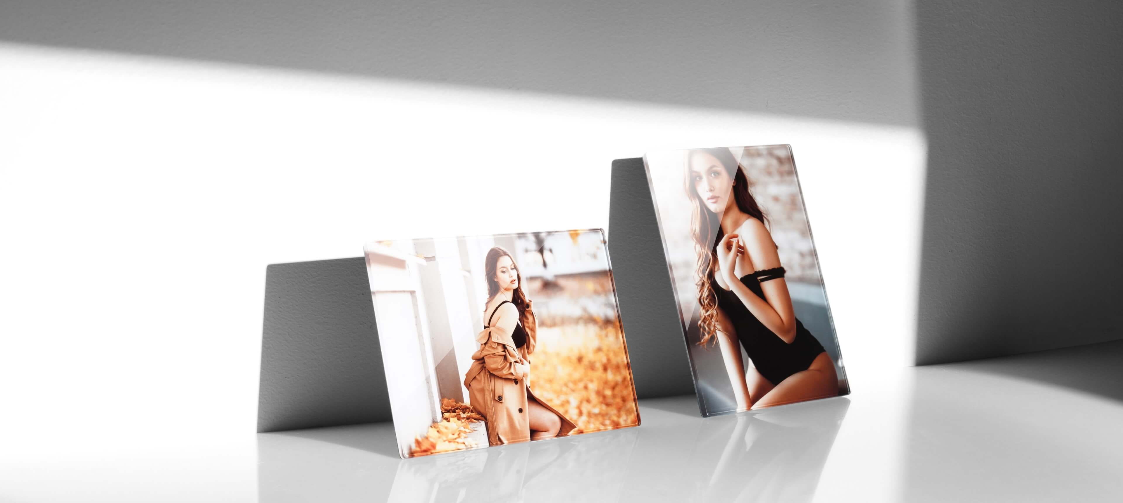 two crystal photo plaques in different orientations standing on a white table showing a woman in lingerie