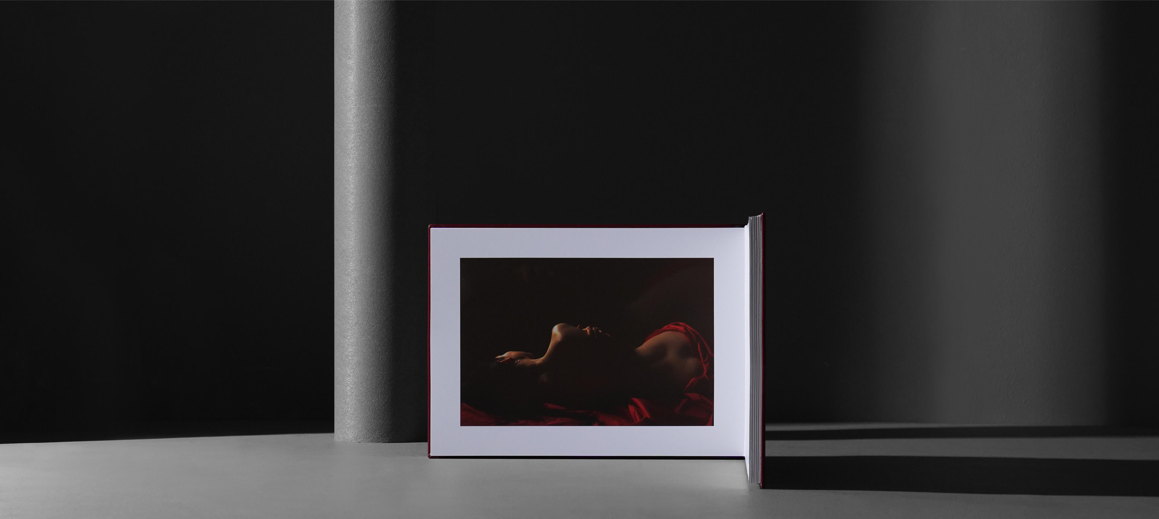 fine art album with an open page of woman laying on her side with a naked back