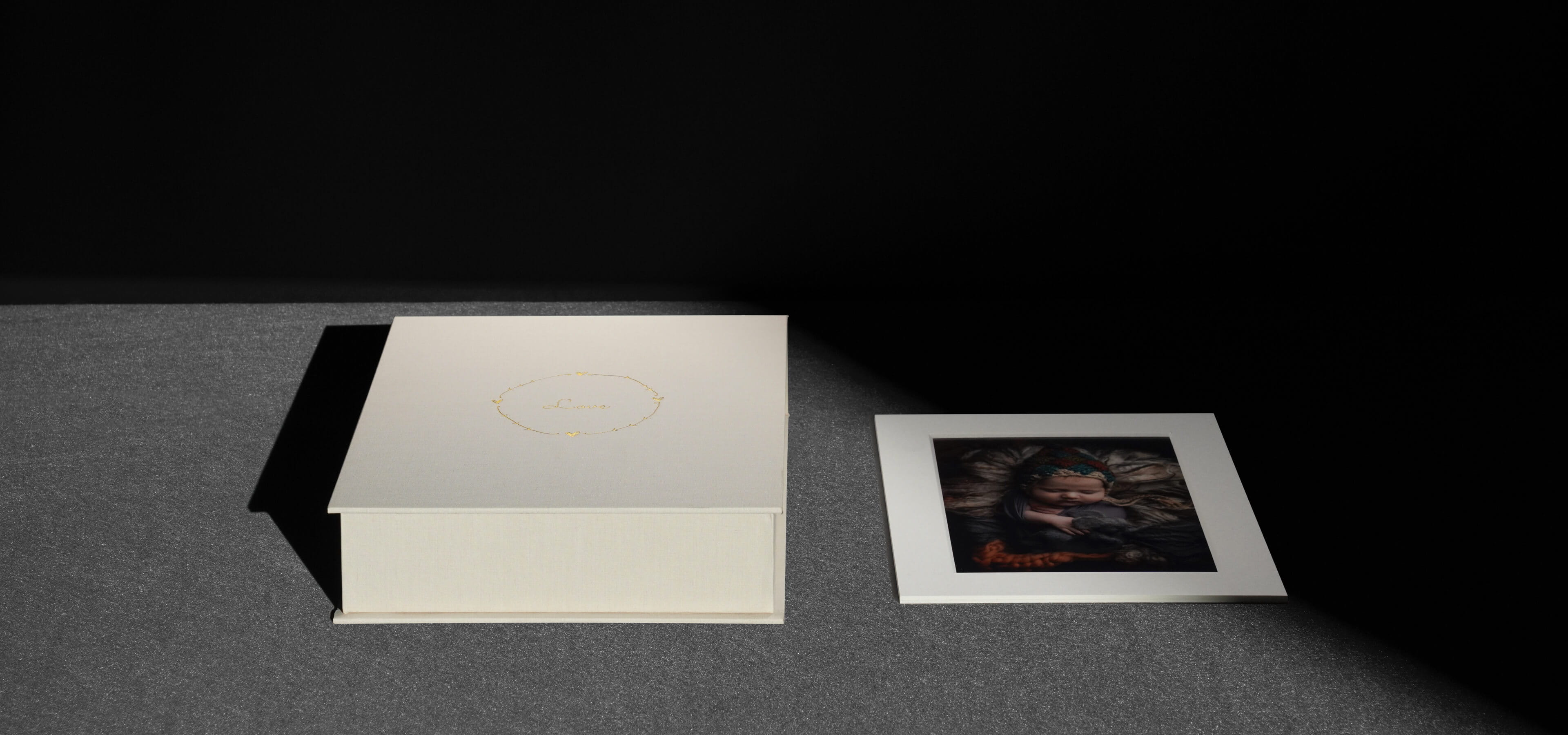 a folio box set showing a matted photo next to a beige linen folio box