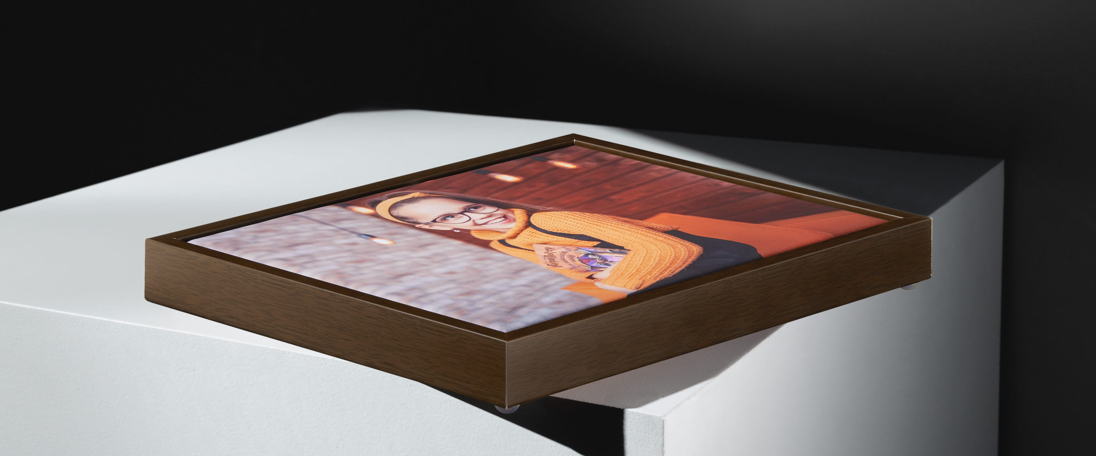 framed canvas with dark wood frame on white table with photo of woman