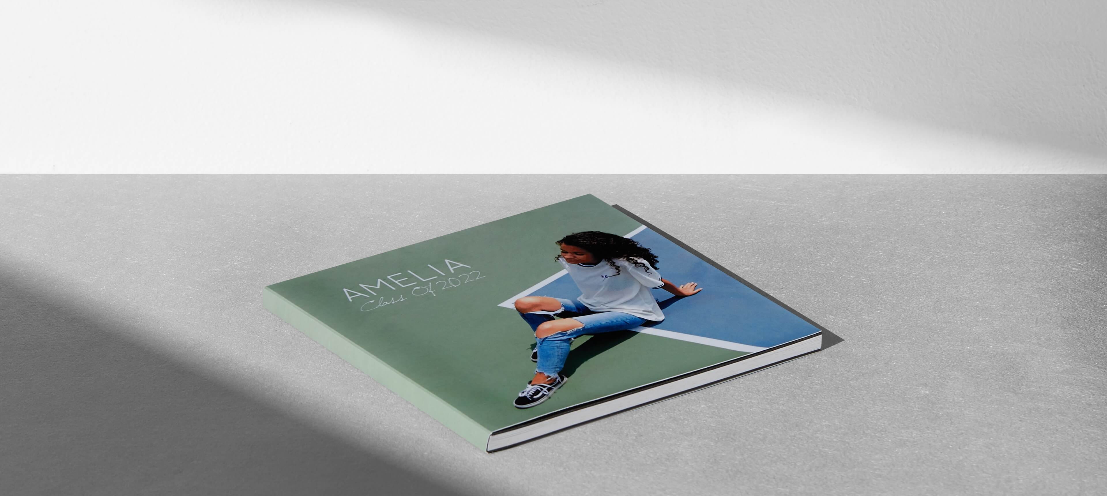 a layflat booklet on grey table showing a woman in jeans