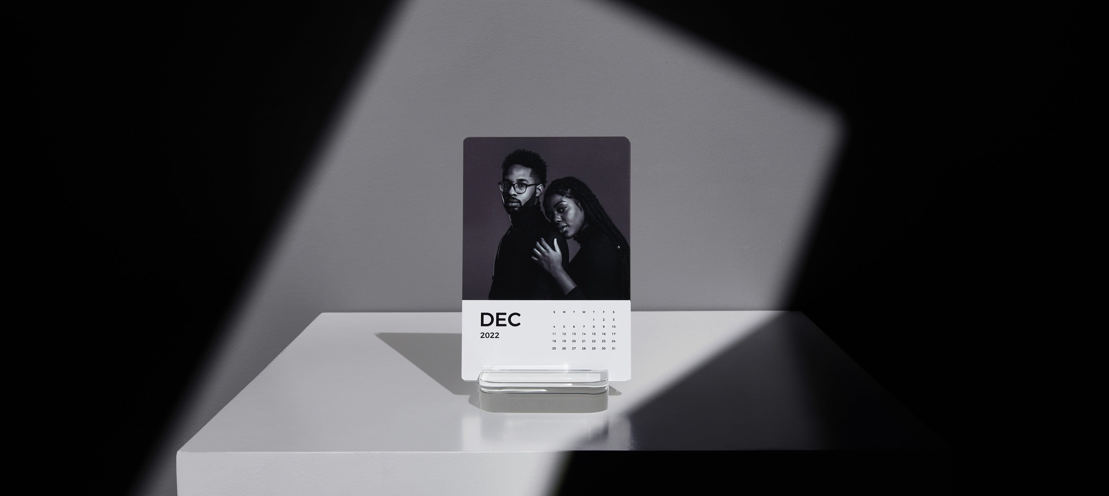 a little moments calendar on a white table showing a couple
