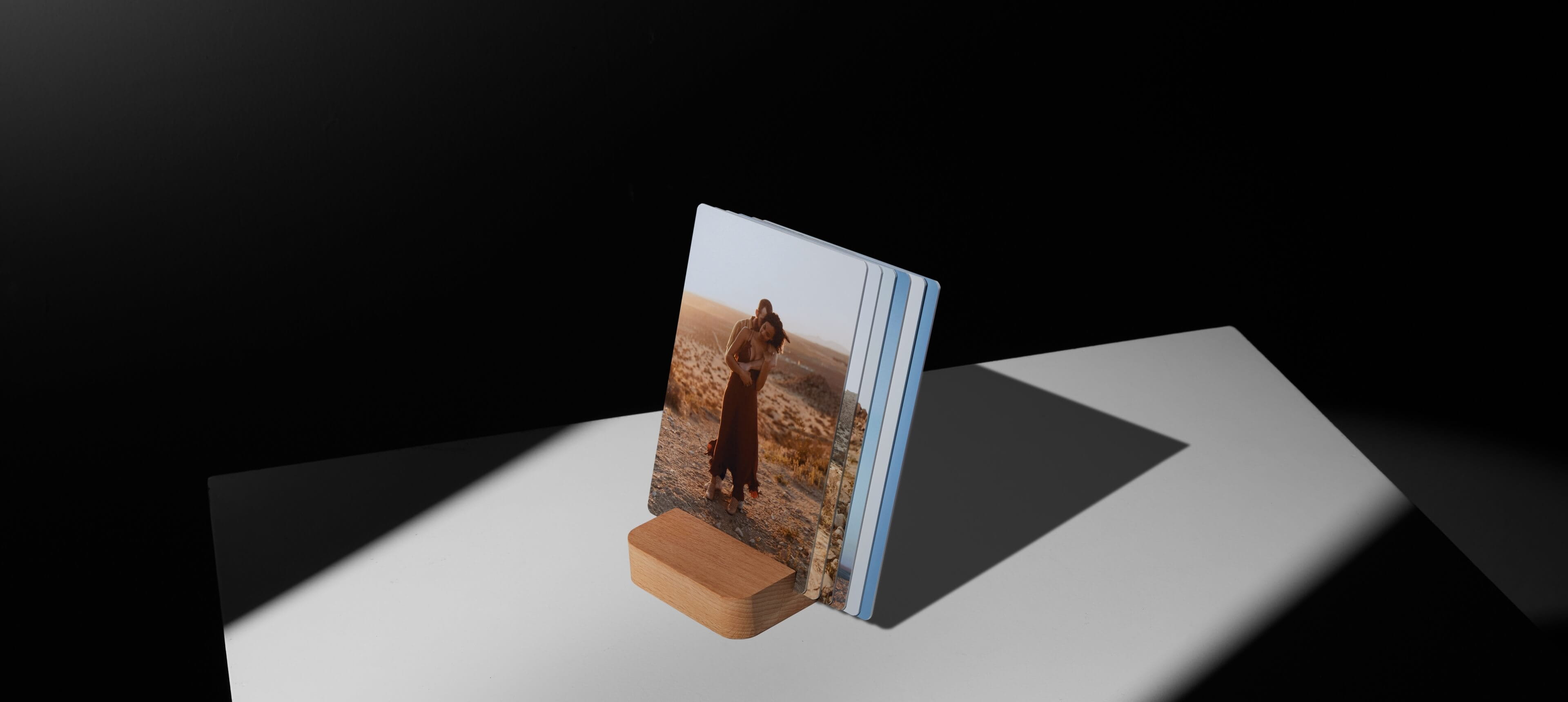 a little prints stand on white surface with multiple prints showing a couple in the desert