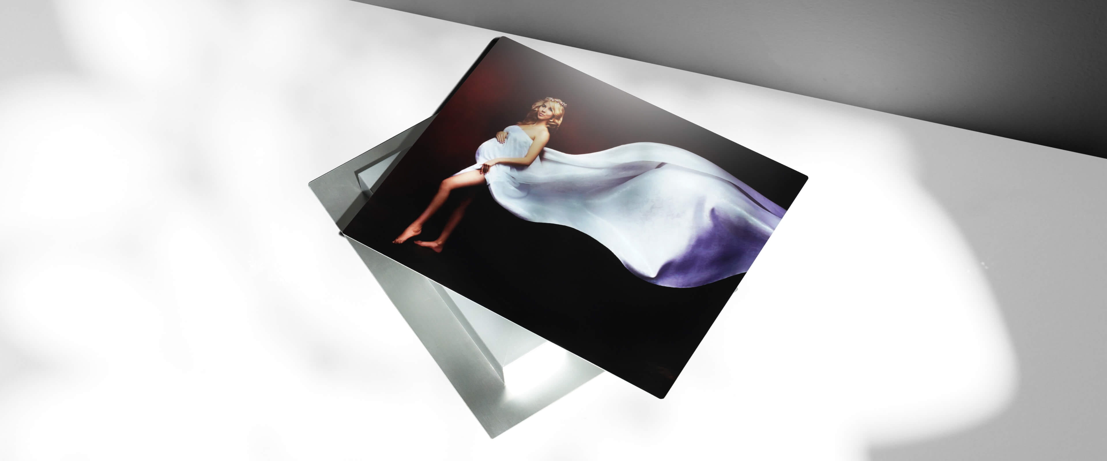metal mounted print stacked on top of another metal mounted print showing pregnant woman