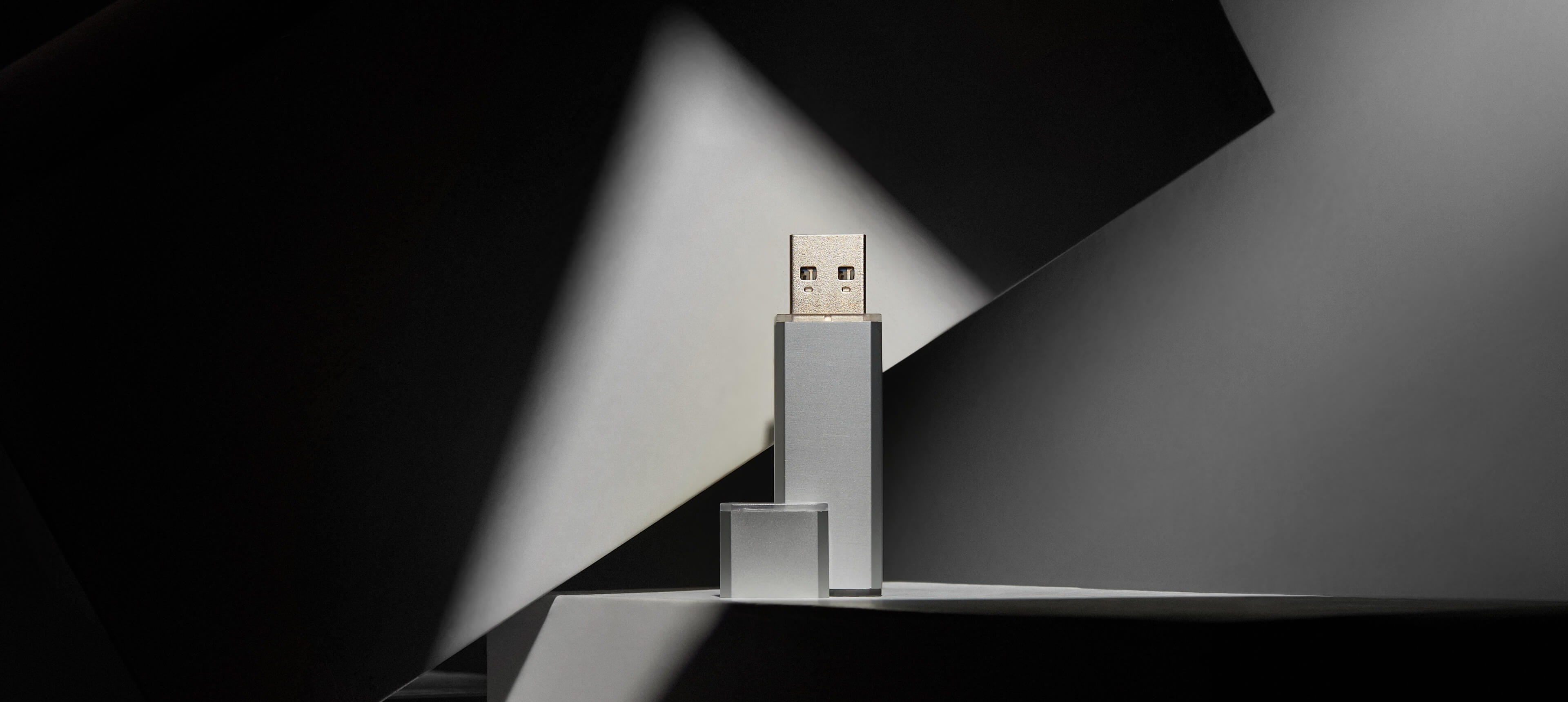 a silver metal usb drive stands on a white table