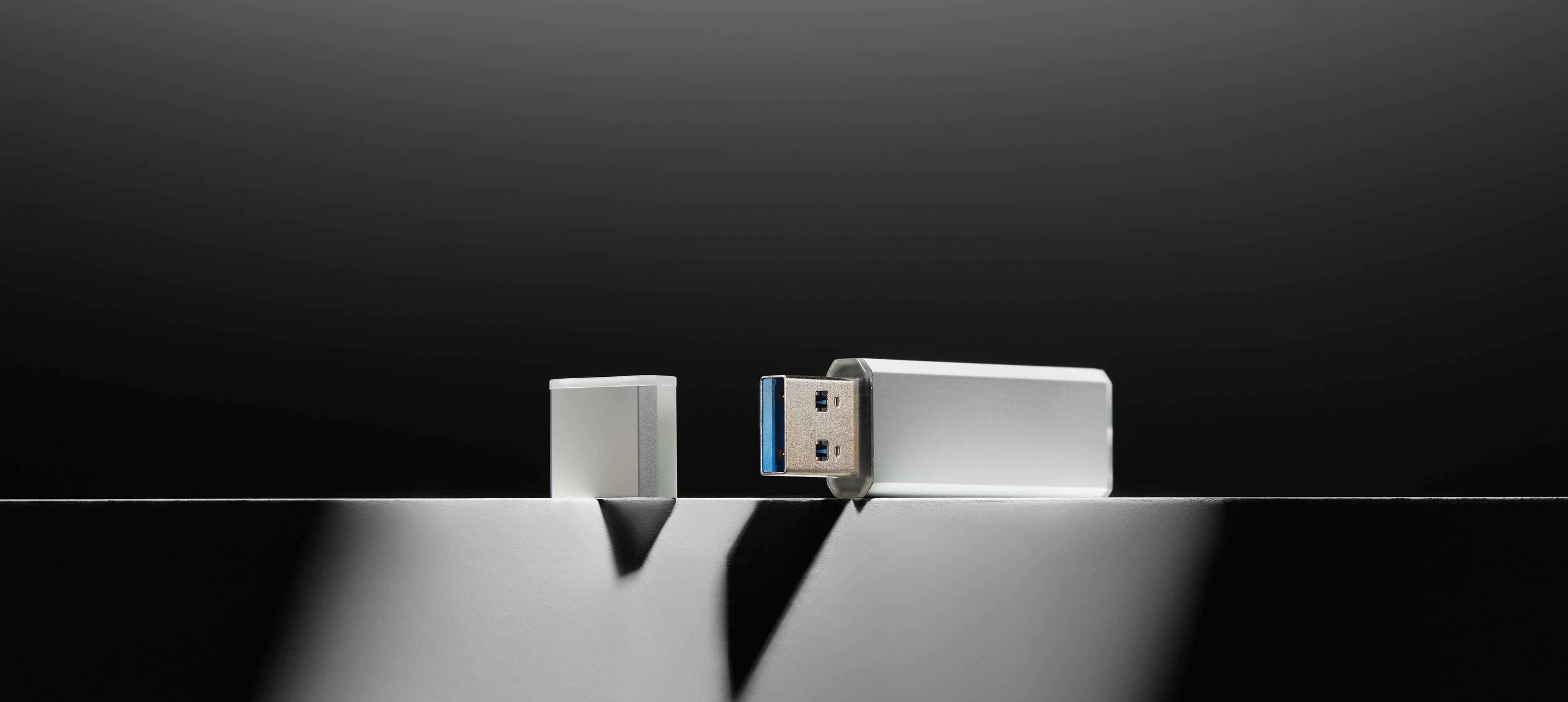 a metal usb drive on a white table