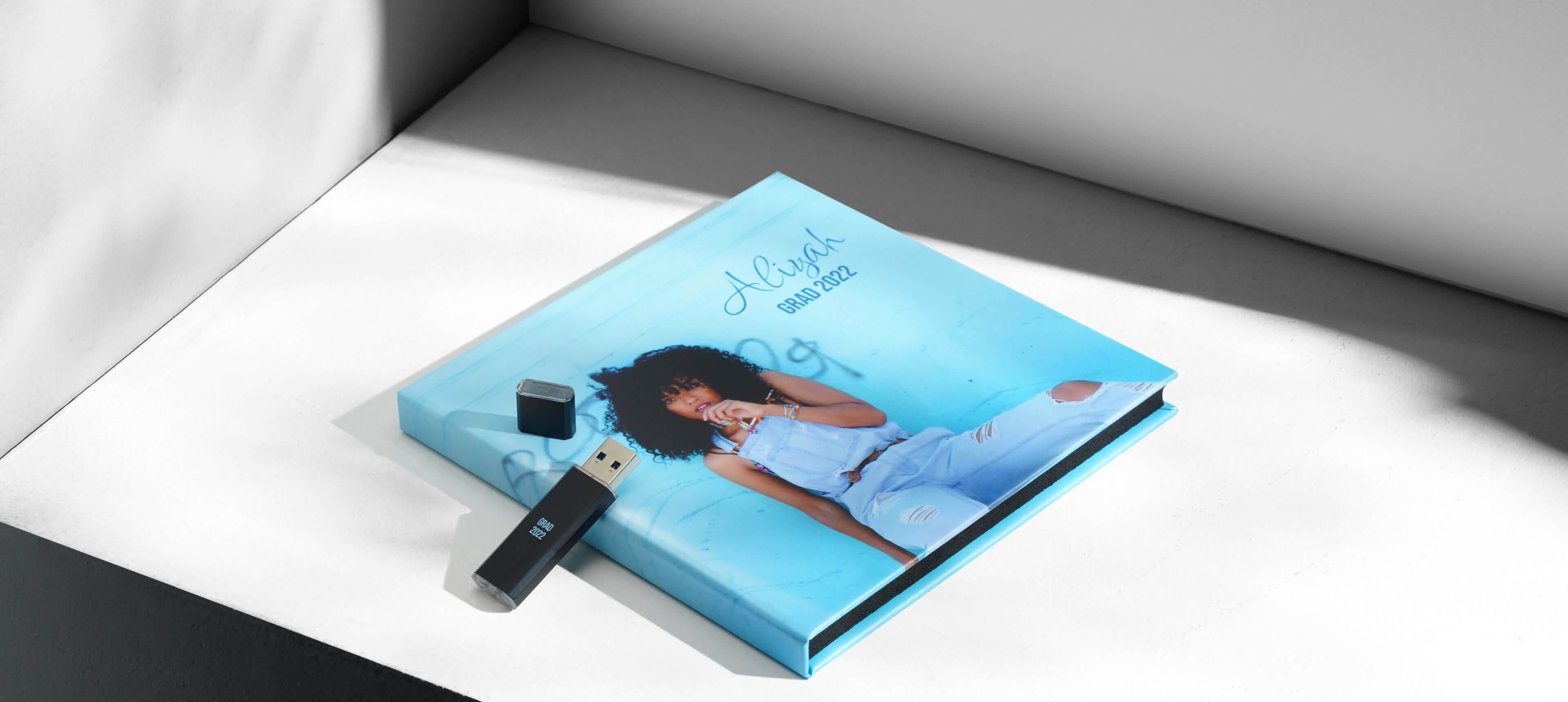 a metal usb drive leaning against a case showing a woman in jeans
