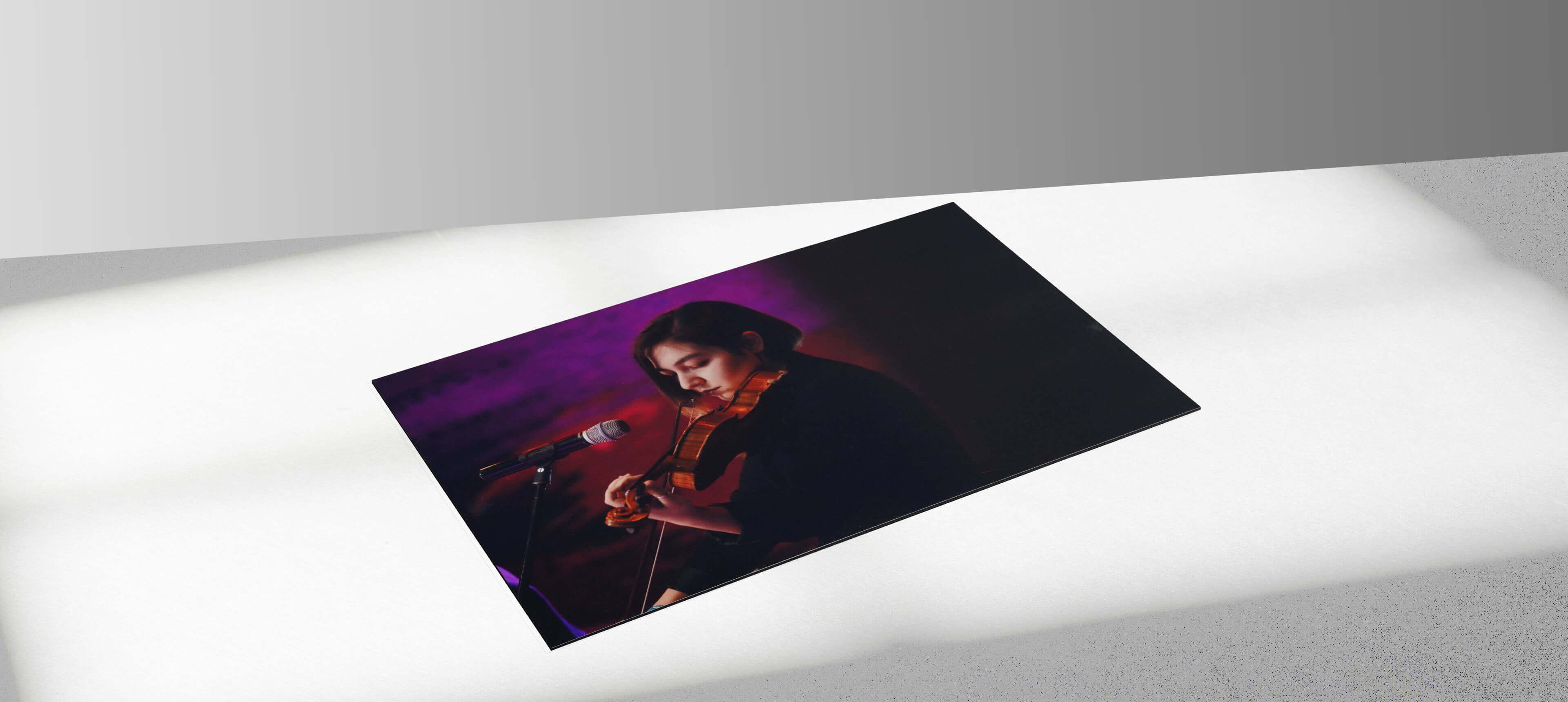 photographic print showing a woman in black sweater playing a violin