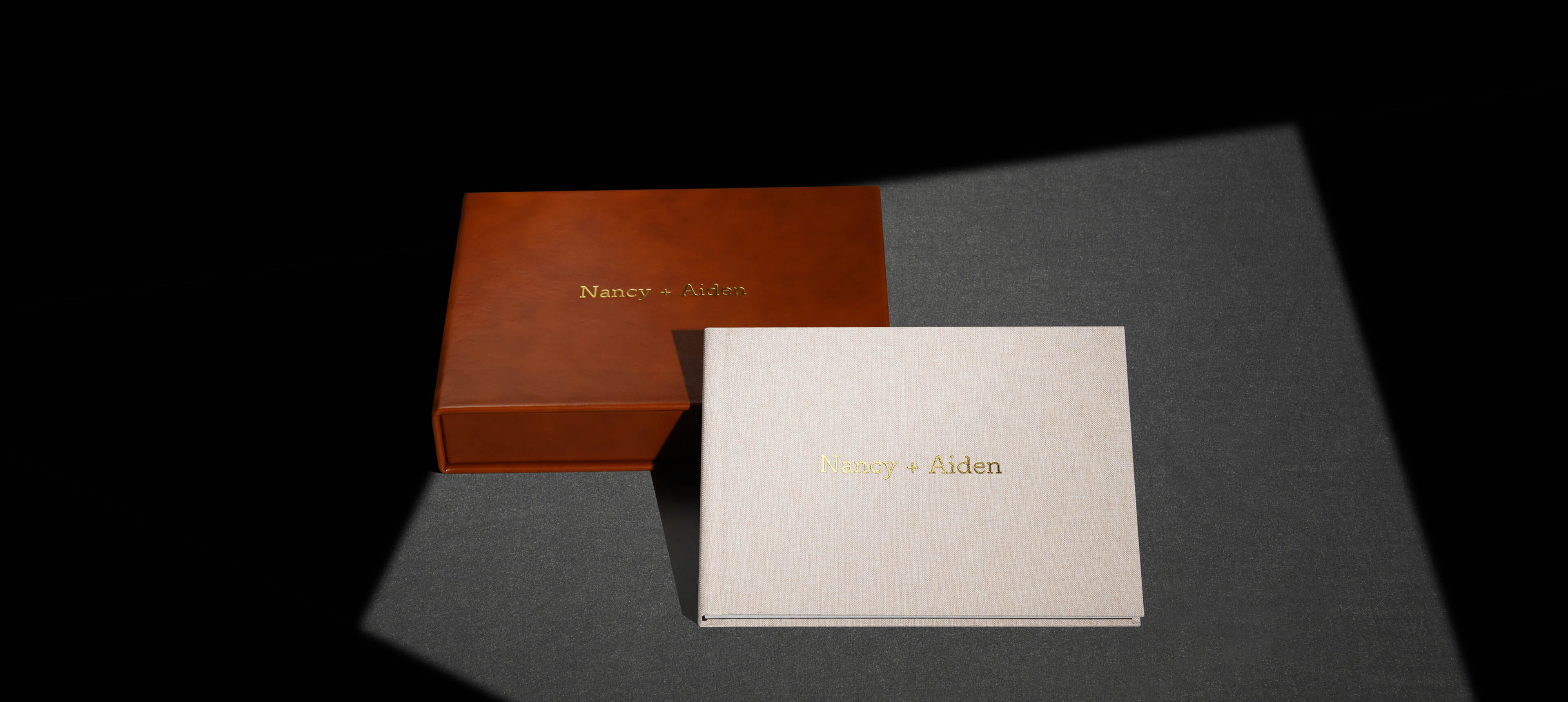 a presentation box album set showing showing a linen photo album leaning against a leather box