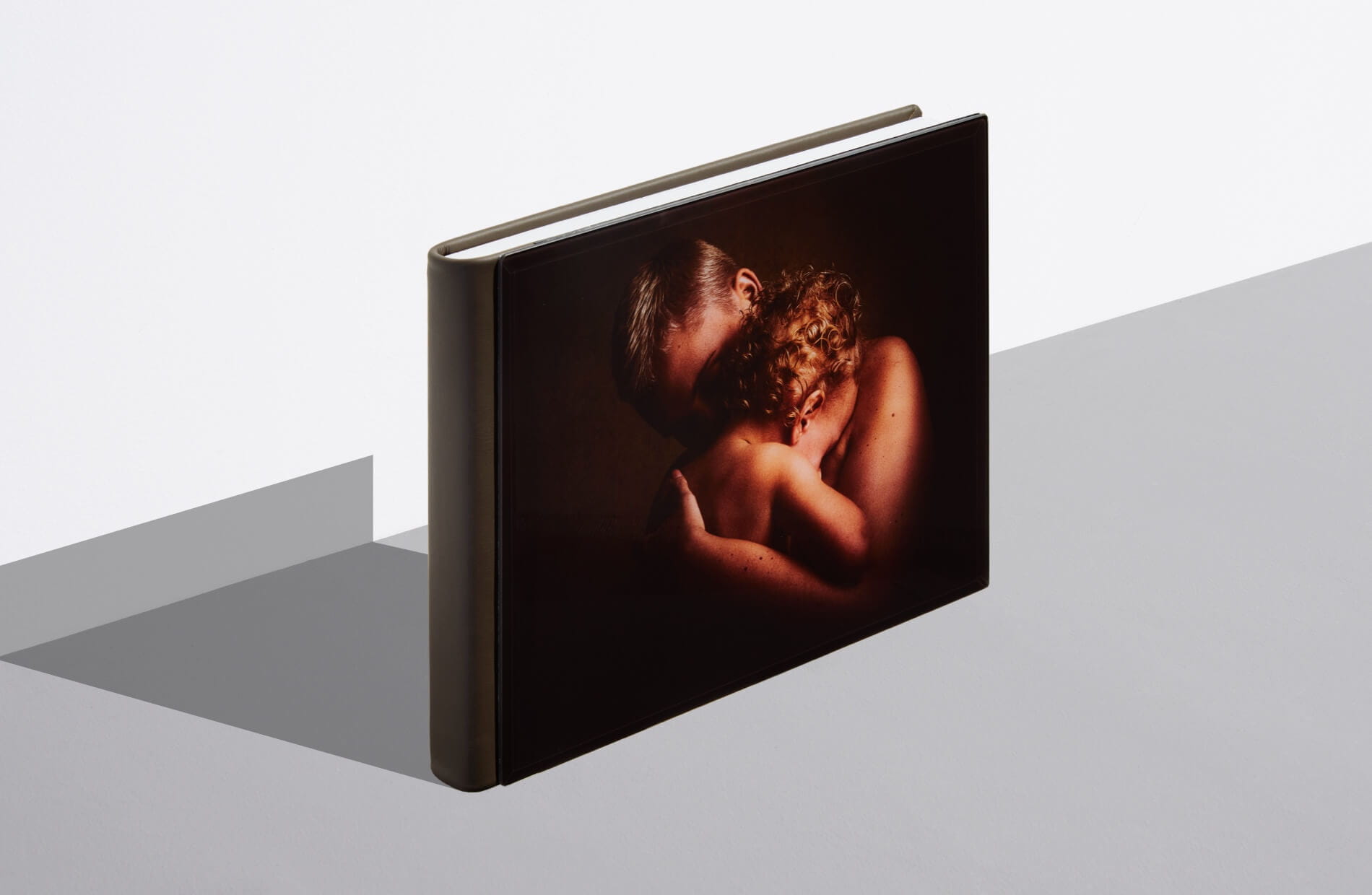 a custom sample album standing on a grey table showing a father and baby
