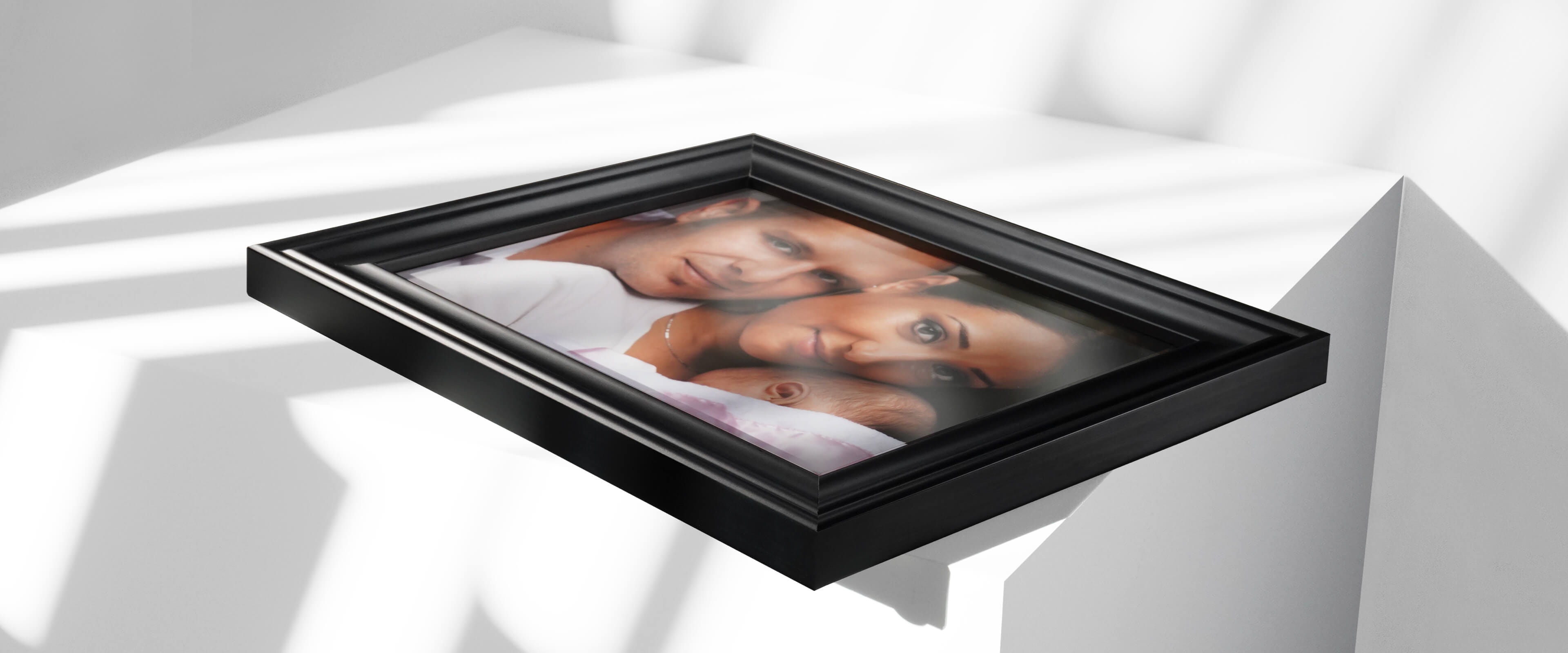 framed print on white table with photo of family holding baby