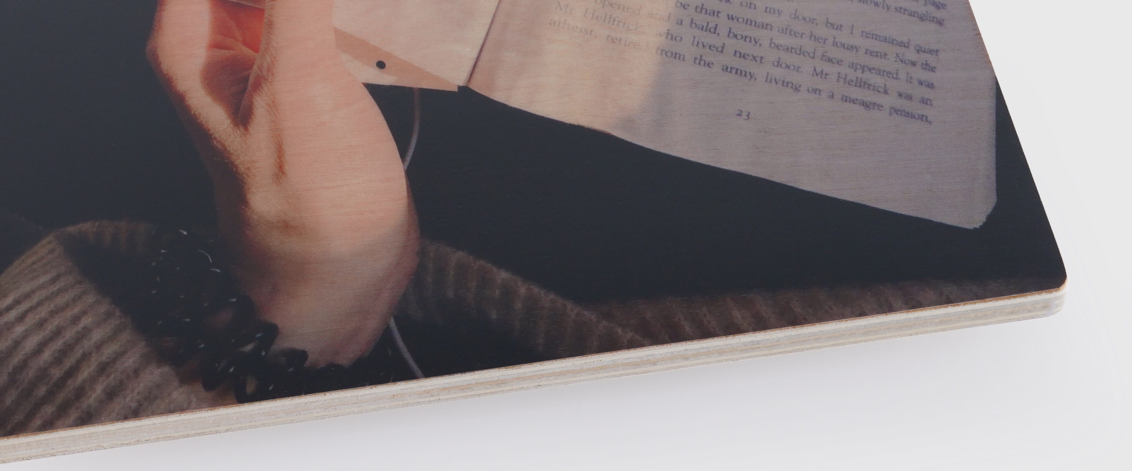 wood print showing photo of hand turning a page in a book